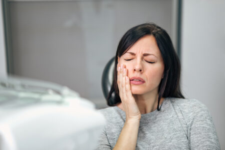 Portrait of a young woman with toothache at dentist office.